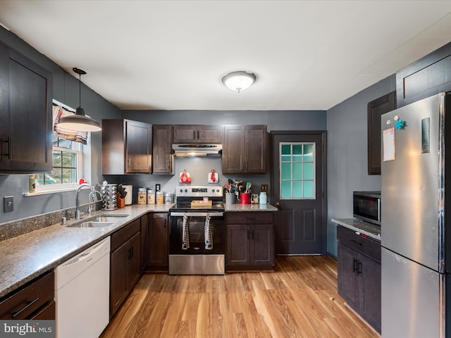 kitchen featuring light wood-style flooring, a sink, appliances with stainless steel finishes, and under cabinet range hood