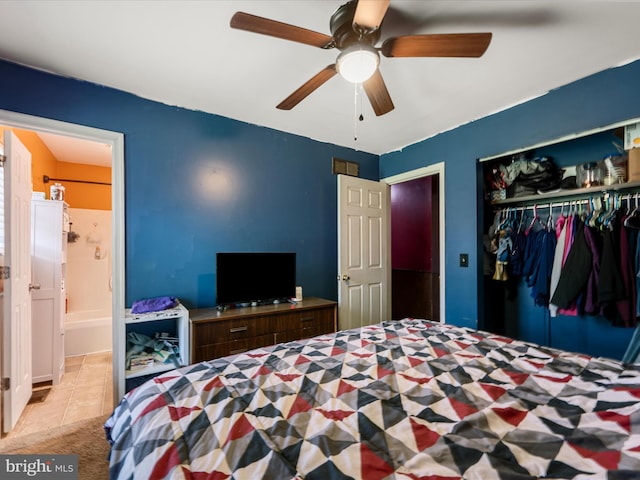 tiled bedroom with a ceiling fan, ensuite bath, and a closet