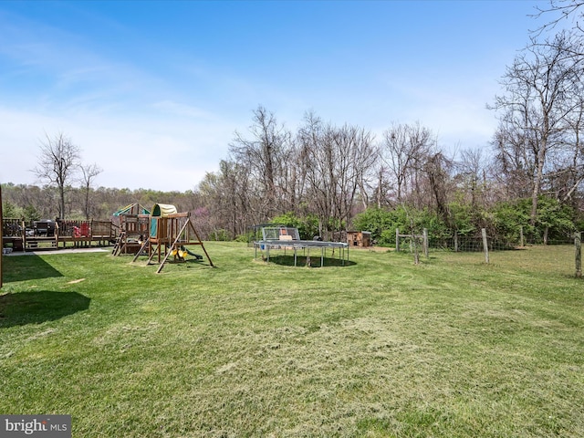view of yard with a trampoline and a playground