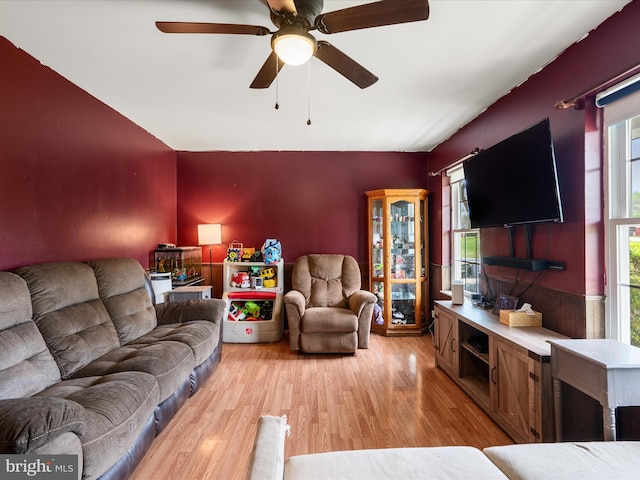 living area featuring light wood finished floors, a ceiling fan, and a wealth of natural light