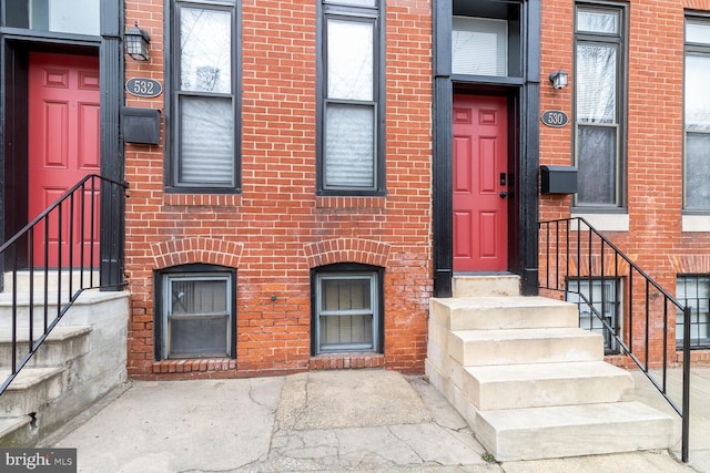 entrance to property featuring brick siding