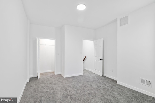 carpeted empty room with visible vents and baseboards