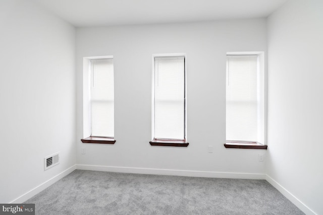 spare room featuring visible vents, baseboards, and carpet floors