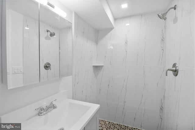 full bath featuring vanity and a marble finish shower