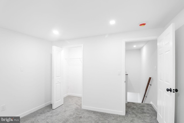 interior space featuring baseboards, recessed lighting, a spacious closet, a closet, and carpet flooring