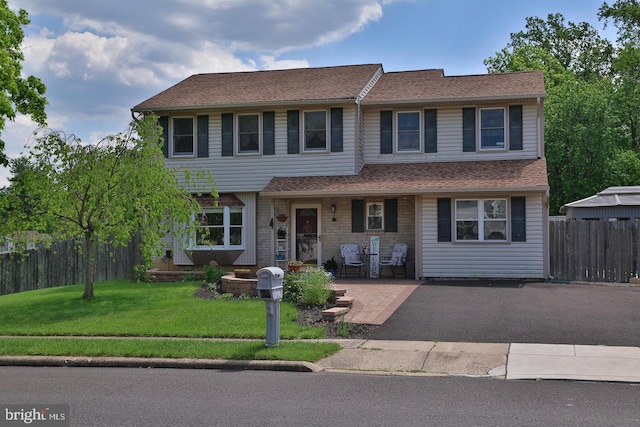 view of front facade featuring a front lawn and fence