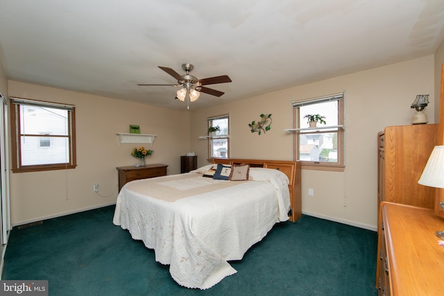bedroom featuring multiple windows, baseboards, and dark carpet