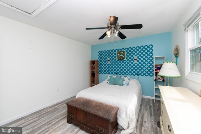 bedroom with a ceiling fan, baseboards, and wood finished floors