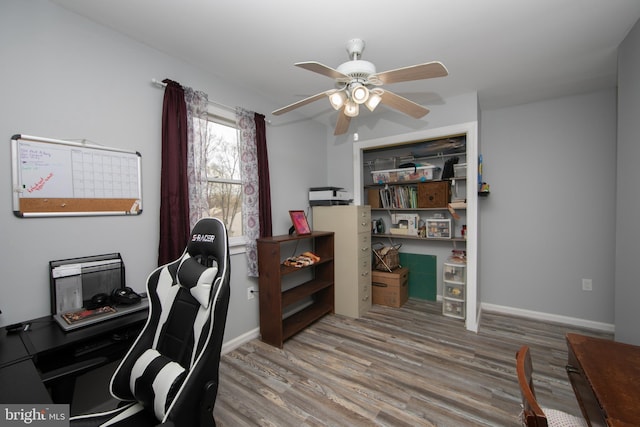 office space featuring baseboards, wood finished floors, and a ceiling fan
