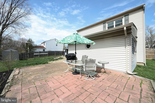 view of patio featuring an outbuilding, a fenced backyard, a storage shed, and area for grilling