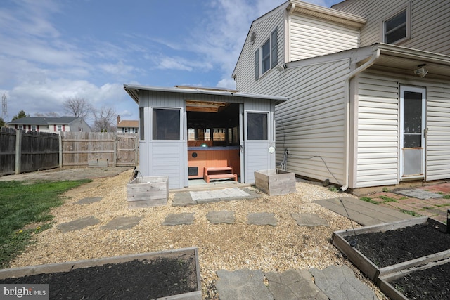back of property featuring a fenced backyard and a vegetable garden