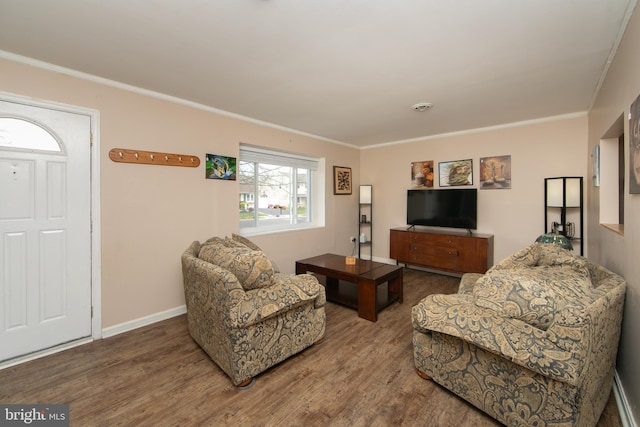 living room with crown molding, baseboards, and wood finished floors