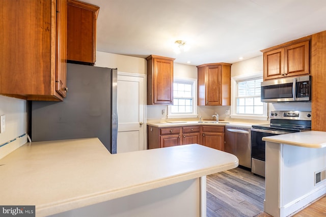526 Baltimore Annapolis Blvd, Severna Park, MD 21146 - kitchen with light countertops, brown cabinets, a peninsula, stainless steel appliances, and a sink