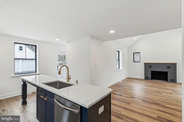 kitchen with dishwasher, light countertops, recessed lighting, light wood-style floors, and a sink