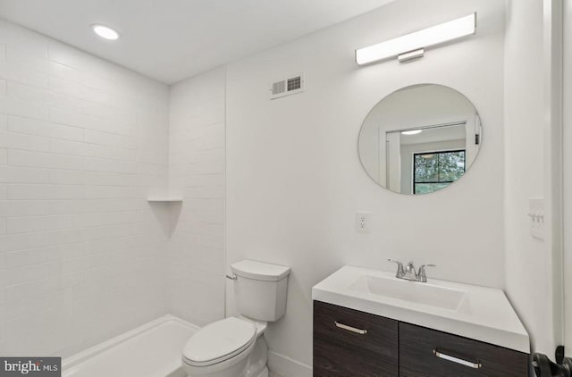 bathroom with vanity, visible vents, recessed lighting, a tile shower, and toilet