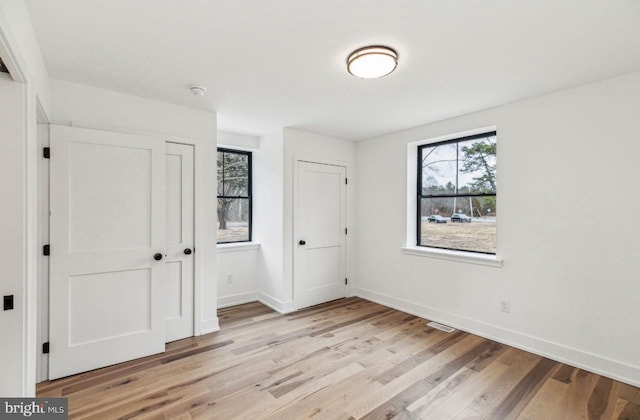 unfurnished bedroom featuring baseboards and light wood-style flooring