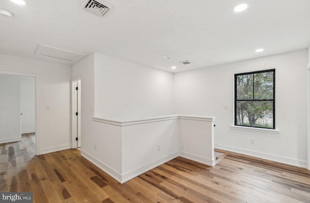 unfurnished room with attic access, recessed lighting, visible vents, and light wood finished floors