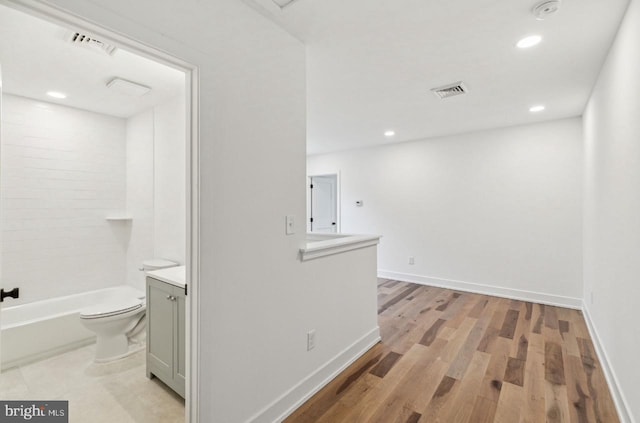 interior space with visible vents, toilet, baseboards, and wood finished floors