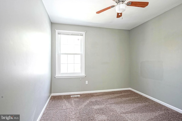 empty room featuring a ceiling fan, visible vents, carpet floors, and baseboards