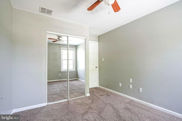 unfurnished bedroom featuring visible vents, ceiling fan, a closet, baseboards, and carpet