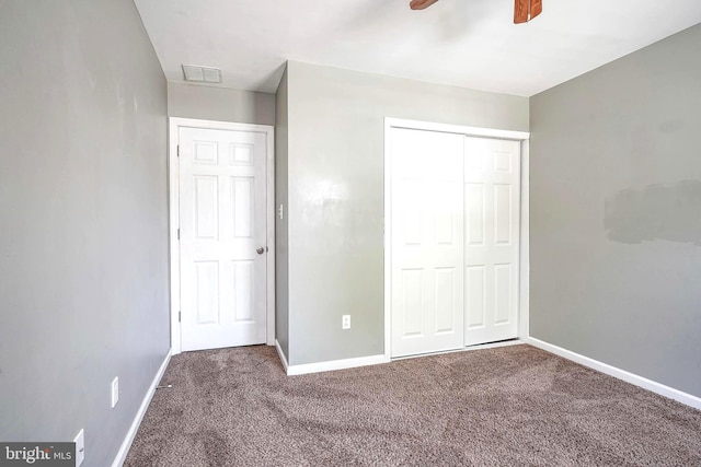 unfurnished bedroom featuring carpet floors, a closet, ceiling fan, baseboards, and visible vents