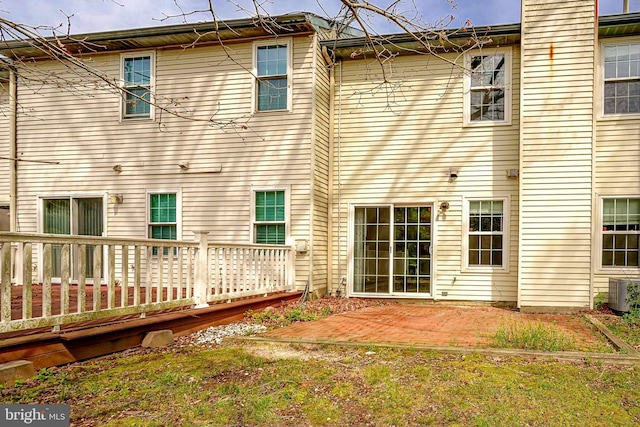 back of house featuring a patio, a wooden deck, and central AC