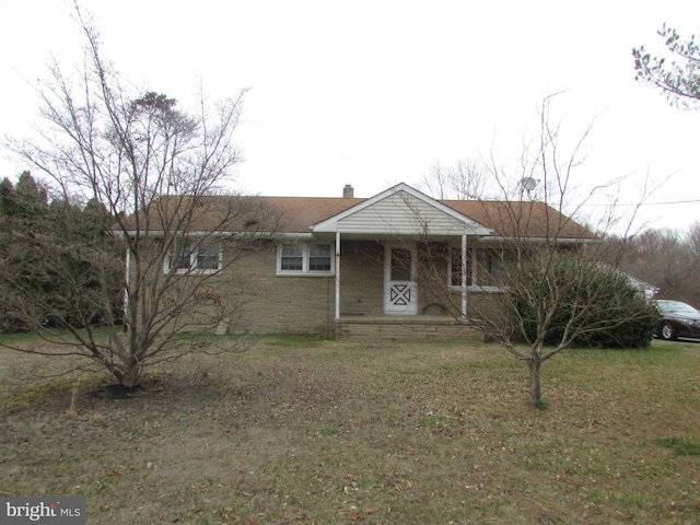 single story home featuring a front yard, covered porch, and a chimney