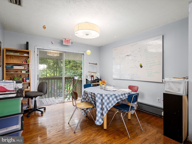 4137 Hedgesville Rd, Hedgesville, WV 25427 - dining area with an office area, baseboard heating, wood finished floors, and a textured ceiling