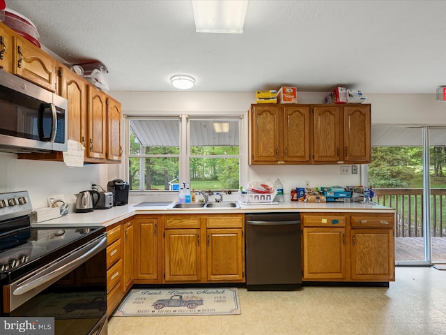 4137 Hedgesville Rd, Hedgesville, WV 25427 - kitchen with appliances with stainless steel finishes, a sink, light countertops, brown cabinetry, and light flooring