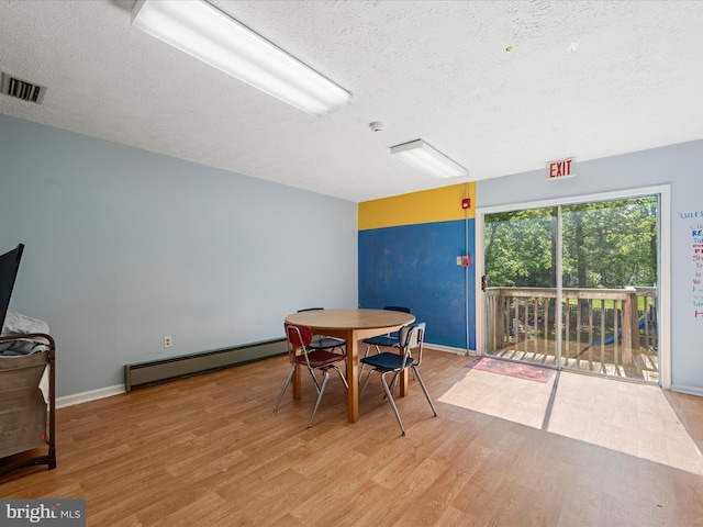 4137 Hedgesville Rd, Hedgesville, WV 25427 - dining area with baseboard heating, a textured ceiling, wood finished floors, and baseboards