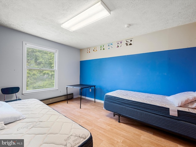 4137 Hedgesville Rd, Hedgesville, WV 25427 - bedroom with a baseboard heating unit, a textured ceiling, and wood finished floors