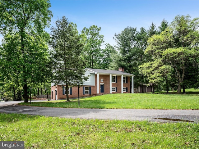 4137 Hedgesville Rd, Hedgesville, WV 25427 - view of front of house with brick siding, a chimney, and a front lawn