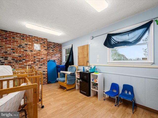 4137 Hedgesville Rd, Hedgesville, WV 25427 - bedroom with a textured ceiling, wood finished floors, and brick wall