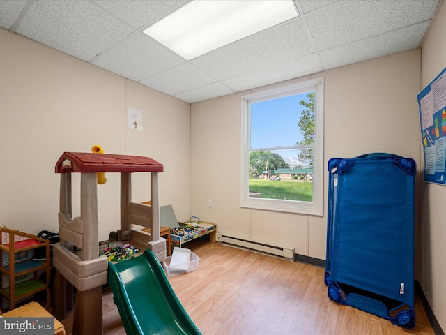 4137 Hedgesville Rd, Hedgesville, WV 25427 - playroom featuring a paneled ceiling, a baseboard radiator, and wood finished floors