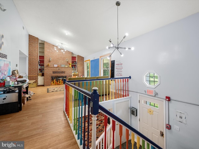4137 Hedgesville Rd, Hedgesville, WV 25427 - hallway with a chandelier, vaulted ceiling, light wood-style flooring, an upstairs landing, and plenty of natural light