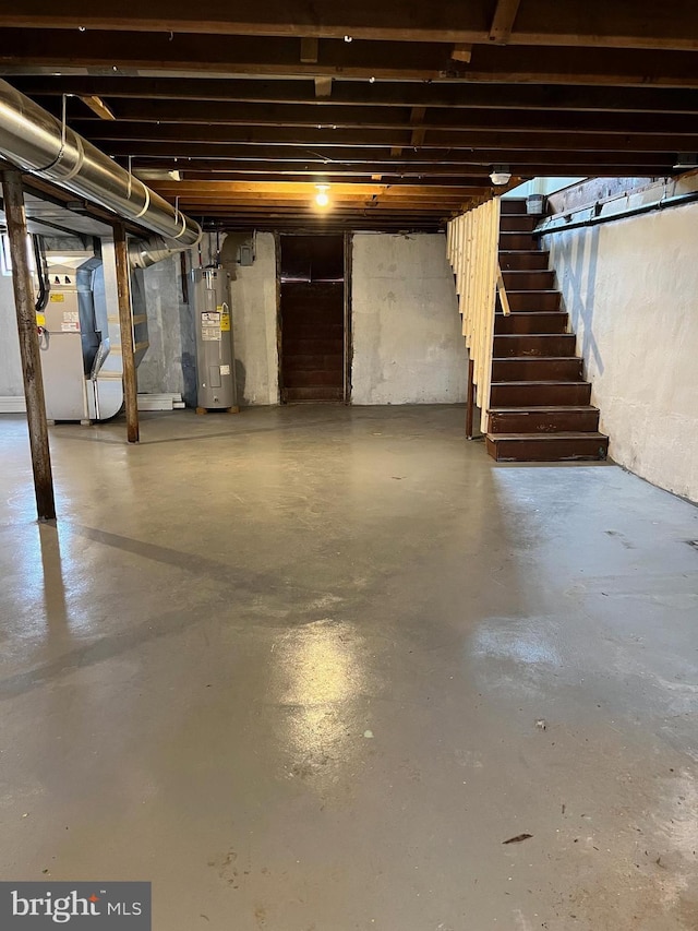 unfinished basement featuring stairway, heating unit, and electric water heater