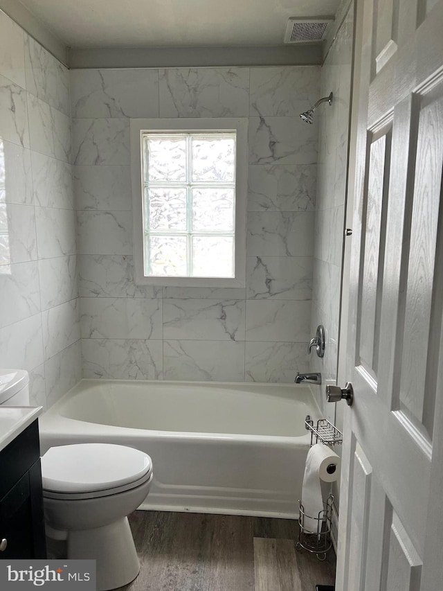 full bath with vanity, wood finished floors, visible vents, bathtub / shower combination, and toilet