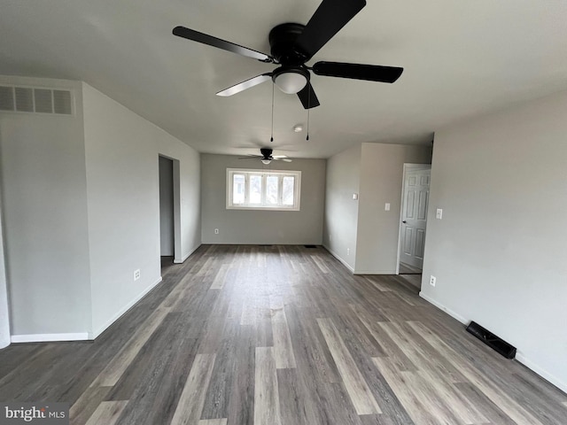 unfurnished living room featuring baseboards, wood finished floors, visible vents, and ceiling fan