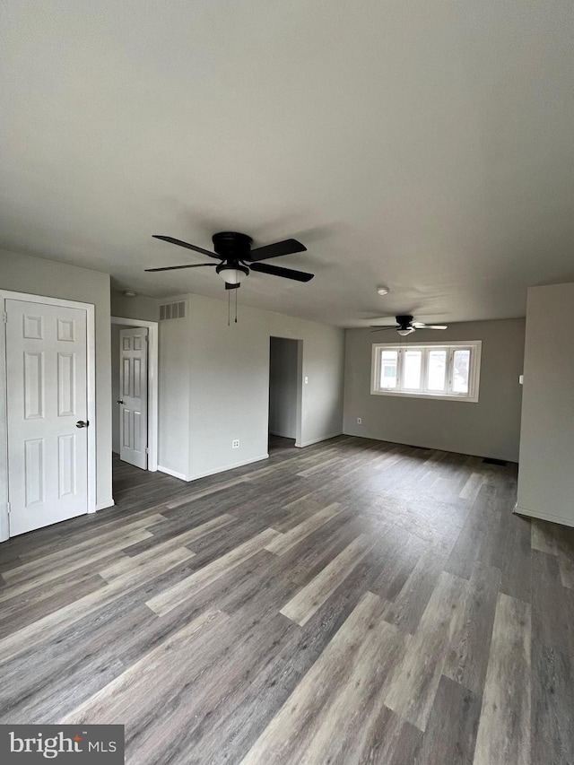 unfurnished living room featuring visible vents, a ceiling fan, and wood finished floors