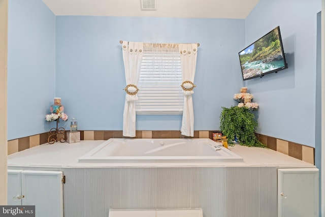 bathroom featuring a bath and visible vents