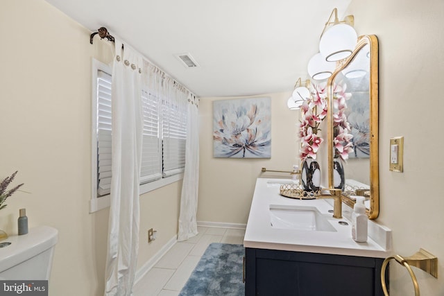 full bathroom with visible vents, toilet, double vanity, tile patterned floors, and a sink