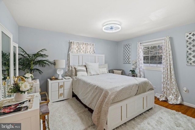 bedroom with baseboards and wood finished floors