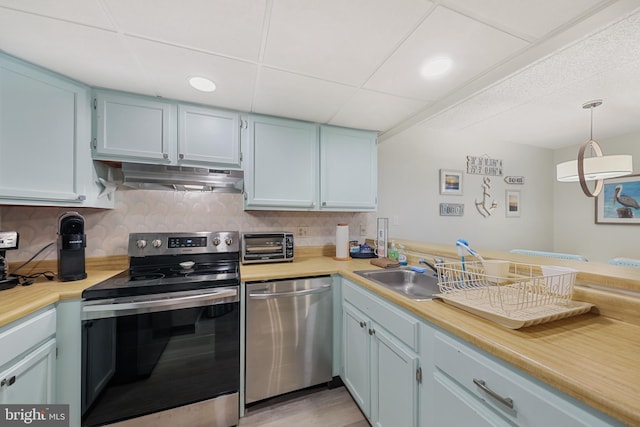 kitchen with under cabinet range hood, stainless steel appliances, a toaster, and light countertops