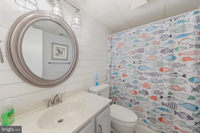 bathroom featuring a shower with curtain, wooden walls, toilet, and vanity