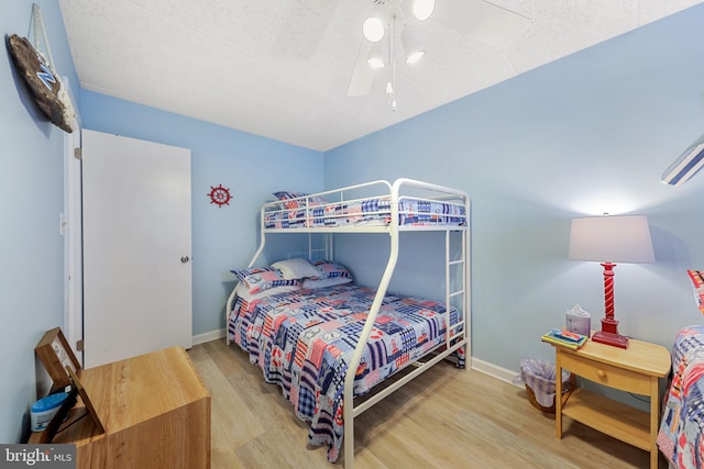 bedroom featuring baseboards, a ceiling fan, and wood finished floors