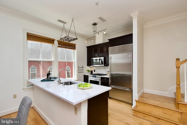 1210 R St NW Unit 313, Washington, DC 20009 - kitchen with high end appliances, a sink, light wood-style flooring, light countertops, and crown molding