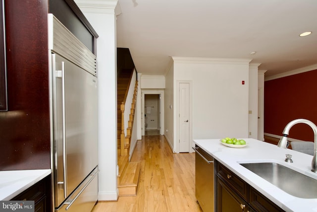 1210 R St NW Unit 313, Washington, DC 20009 - kitchen with a sink, stainless steel appliances, light wood-style floors, light countertops, and ornamental molding