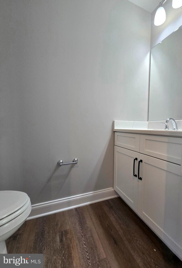 211 Greenland Beach Rd, Baltimore, MD 21226 - half bathroom with baseboards, wood finished floors, toilet, and vanity