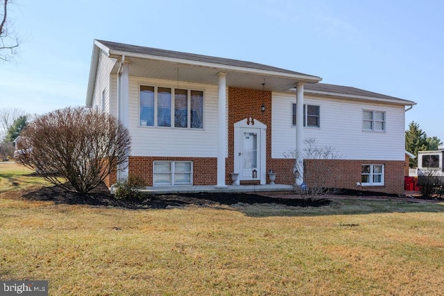 split foyer home featuring brick siding and a front yard
