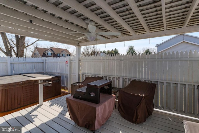 deck with a fenced backyard, a ceiling fan, and a hot tub